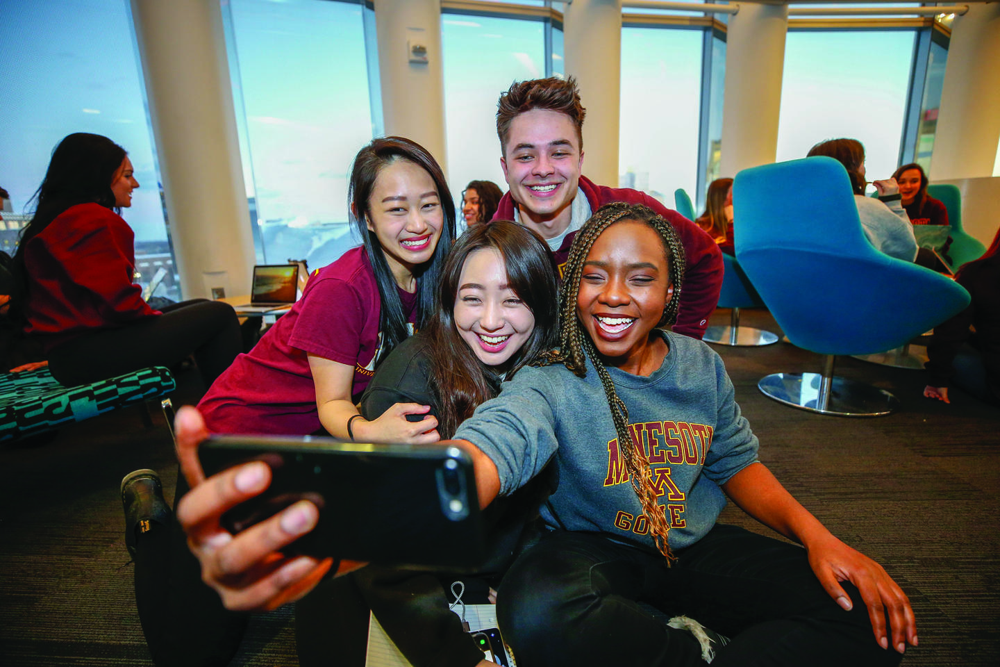 Four students standing together, taking a selfie