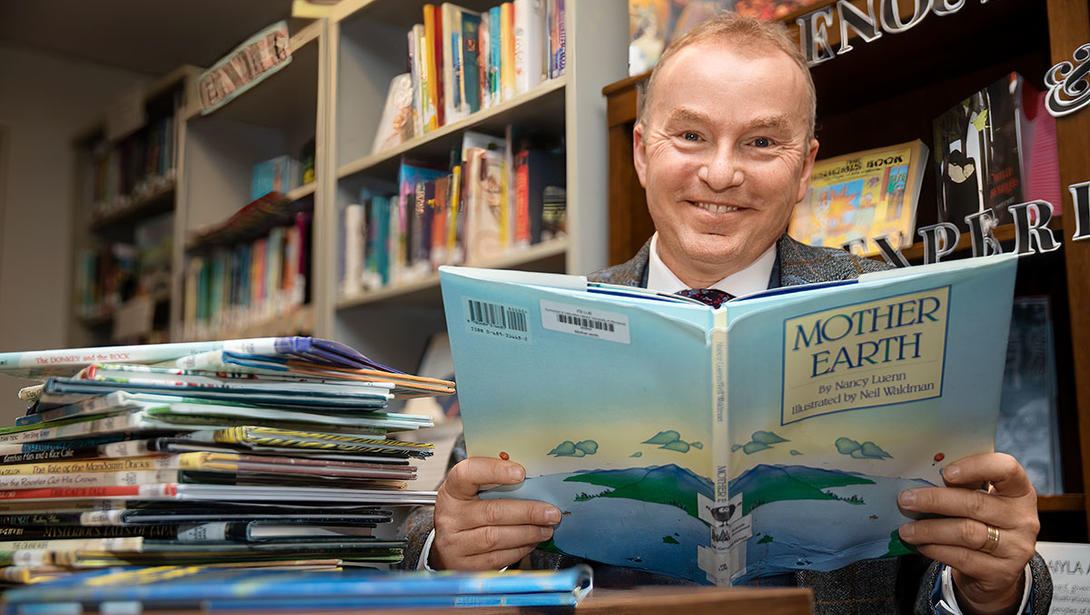 Marek Oziewicz with a stack of environment-related children's books